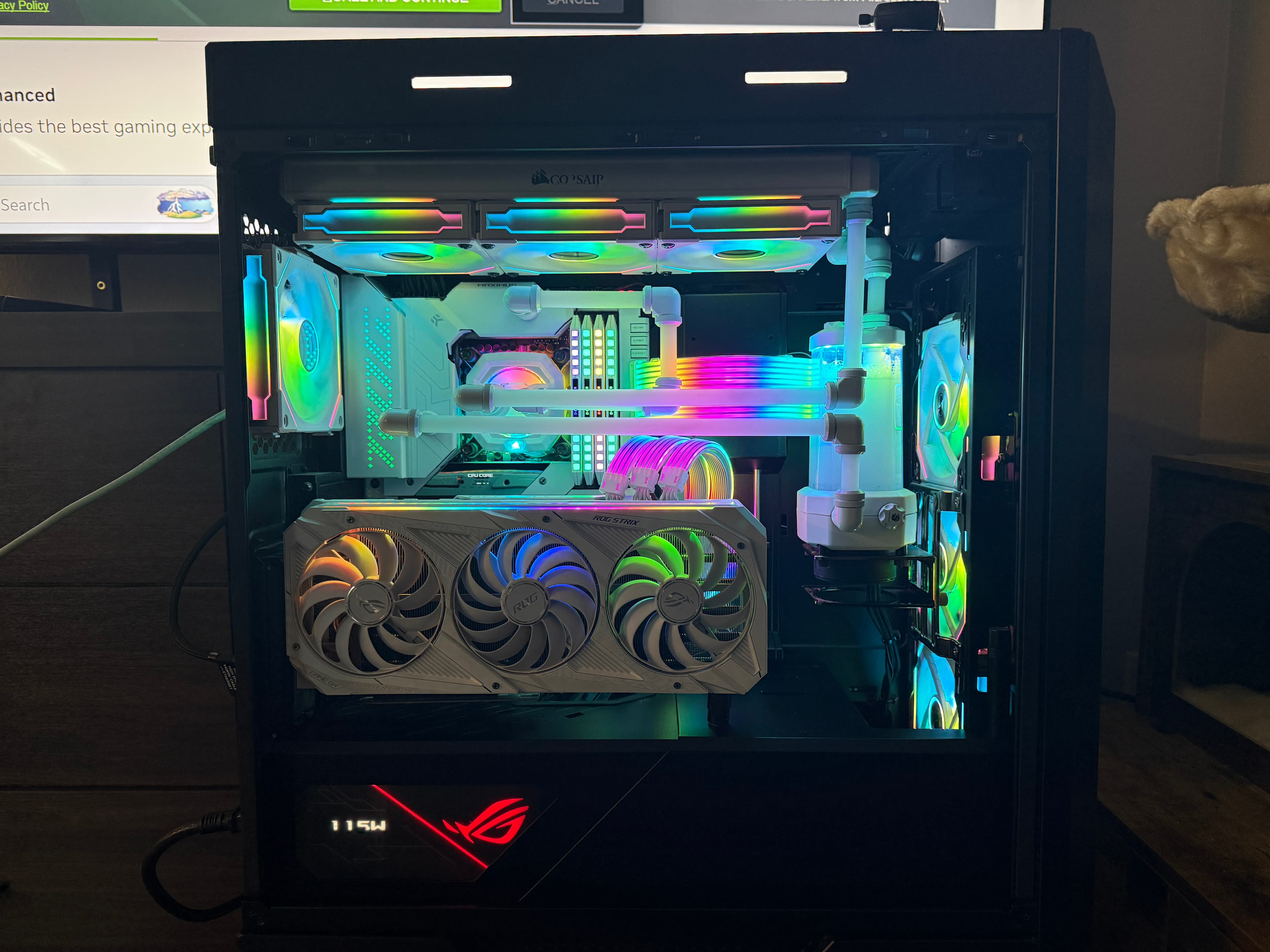 White gaming PC featuring custom liquid cooling, vertical GPU, and vibrant rainbow RGB lighting throughout.
